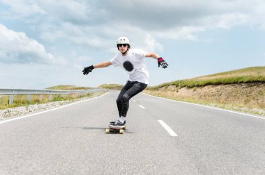 Kask içinde genç bir adam, yağmur altında yüksek hızda bir ülke yolda sürme