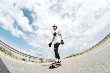 Kask içinde genç bir adam, yağmur altında yüksek hızda bir ülke yolda sürme