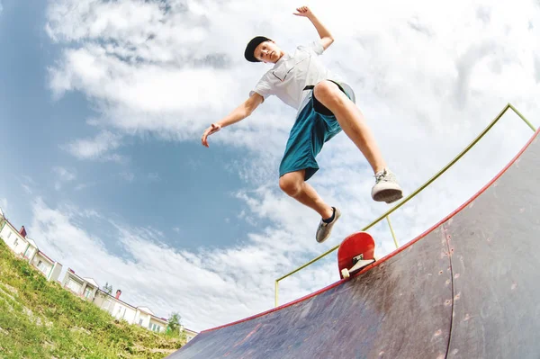 Joven patinador salta desde la rampa hacia abajo —  Fotos de Stock