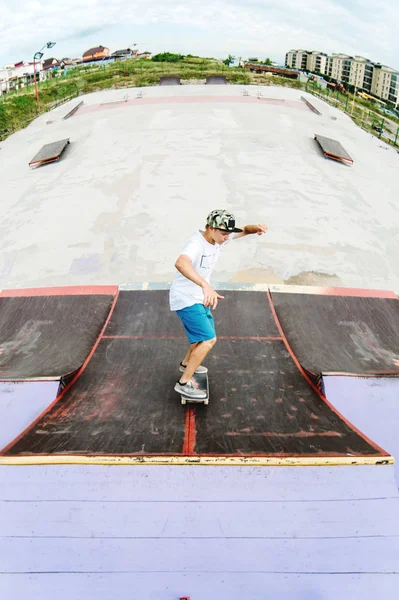 Teen patenci sürmek bir rampa üzerinde bir skate Park bir kaykay üzerinde