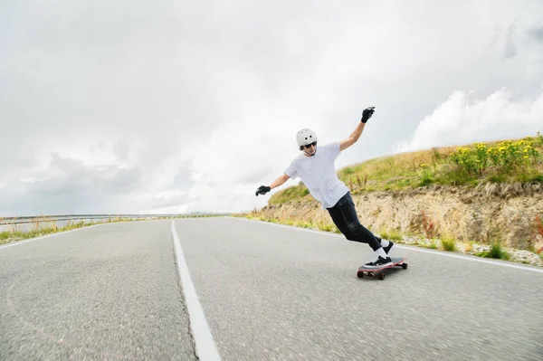 Genç bir adam karmaşık bir dublör bir longboard üzerinde gerçekleştirir. — Stok fotoğraf