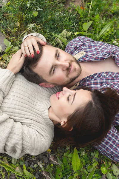 Milující pár bokovky ležela na trávě — Stock fotografie