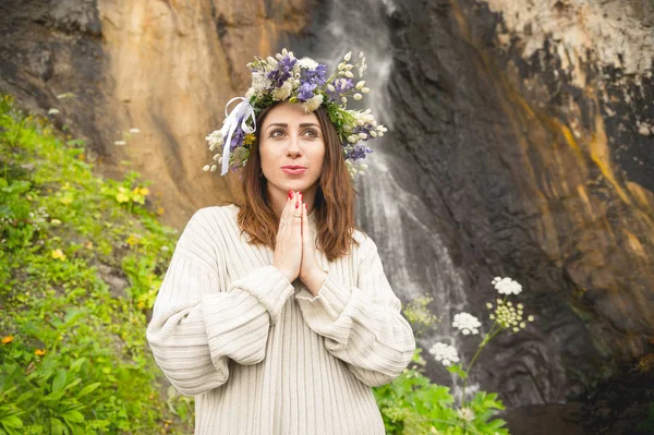 Retrato de uma menina com uma coroa de flores na cabeça contra uma cachoeira — Fotografia de Stock