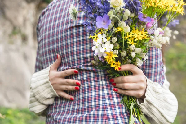 Primer plano de un abrazo de manos pareja de chico y su novia con ramo — Foto de Stock