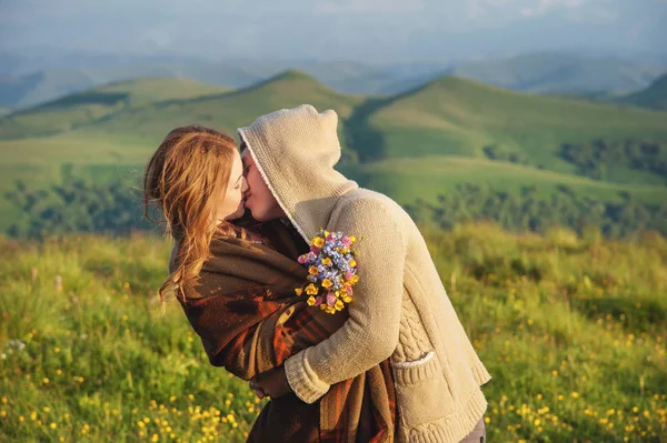 Молодая счастливая пара целуется на природе против красивого кавказского пейзажа . — стоковое фото