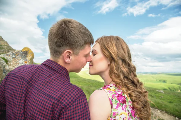 Egy fiatal házas pár eléri a csók, a háttérben a gyönyörű természet — Stock Fotó
