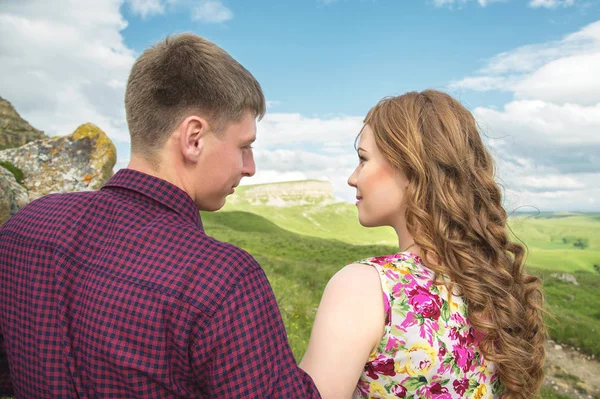 Молода подружня пара досягає поцілунку на тлі красивої природи — стокове фото