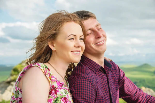 Young married couple laughing happily in nature against the background of rocks and stones — Stock Photo, Image