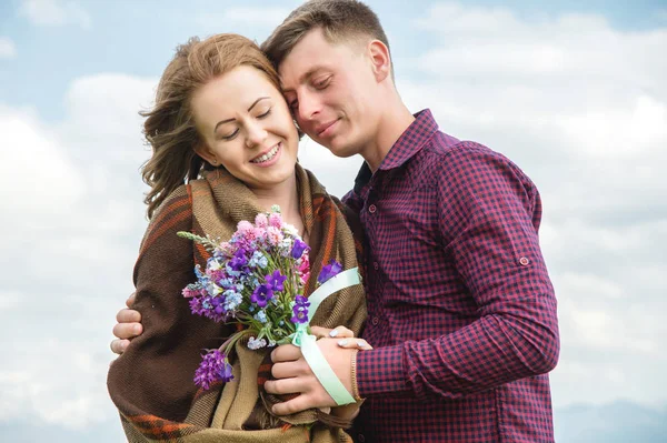 Jeune couple amoureux embrasse doucement contre le ciel bleu et les nuages blancs — Photo