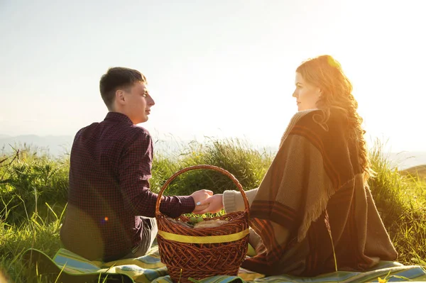 Вид со спины. Молодая супружеская пара на пикнике на открытом воздухе — стоковое фото