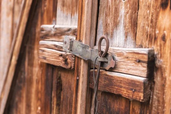 Старий простий замок на дерев'яних дверях закритий металевим штифтом сільська засувка на старих дверях з дерева — стокове фото