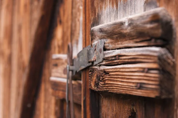 Old simple lock on a wooden door closed with a metal pin rustic latch on an old door made of wood — Stock Photo, Image