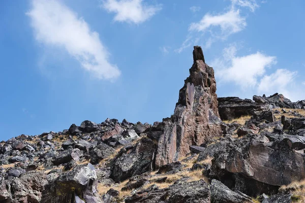 Mavi gökyüzü ve beyaz bulutlar karşı yüksek dağlık keskin kayalar. Caucasus — Stok fotoğraf