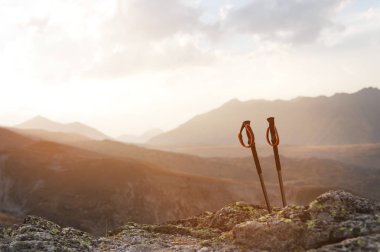Profesyonel bir stone yakınındaki bir dağ üzerinde mavi bir gökyüzü ve beyaz bulutlar karşı yüksek dağ yolu sunset bulvarında tırmanış için sopa