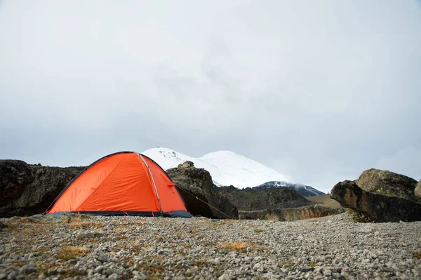 Una carpa naranja de gran altitud se coloca en lo alto de las montañas sobre el fondo de la cresta caucásica —  Fotos de Stock