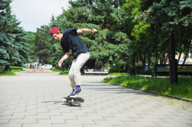 Uzun saçlı skater-genç bir tişört ve spor ayakkabı şapka fırtınalı gökyüzü karşı bir ara sokakta atlar