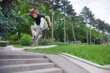 Uzun saçlı skater-genç bir tişört ve spor ayakkabı şapka fırtınalı gökyüzü karşı bir ara sokakta atlar
