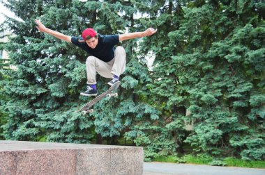 Uzun saçlı skater-genç bir tişört ve spor ayakkabı şapka fırtınalı gökyüzü karşı bir ara sokakta atlar