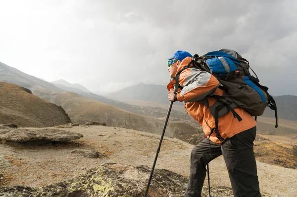 Osamělý turista s výhledem vysokou v horách kde není žádná tráva vesnice a sněhu — Stock fotografie