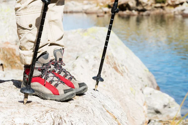 Detail z ženských nohou v turistických botách s holemi pro Nordic walking na pozadí skal a dalekých kavkazských zemí — Stock fotografie