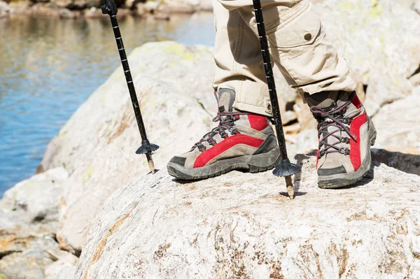 Detail z ženských nohou v turistických botách s holemi pro Nordic walking na pozadí skal a dalekých kavkazských zemí — Stock fotografie