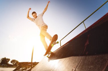 Teen skater bir rampa skate Park bir kaykay üzerinde üzerinde kapat