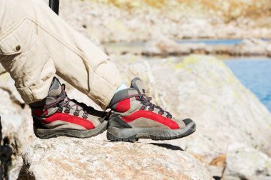Trekking botları kaya ve uzak Kafkas topraklarda arka planı kadın bacakları Close-Up