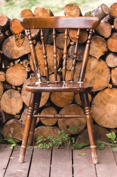 Старий старовинний стілець на фоні колоди дерев'яних пиломатеріалів — стокове фото