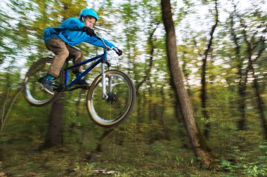 genç bir adam bir kask içinde sinekler bir kicker atladıktan sonra bir bisiklet üzerinde indi