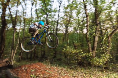 bir kask içinde genç bir adam bir kicker atladıktan sonra bir bisiklet üzerinde uçar