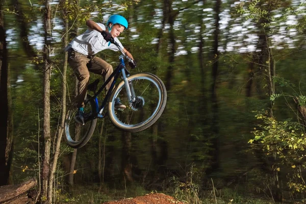 Un ragazzo con il casco vola in bicicletta dopo essere saltato da un kicker — Foto Stock