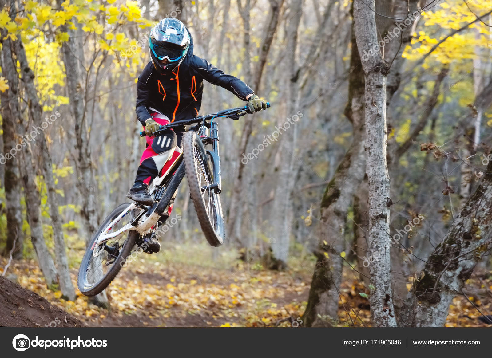 A young rider at the wheel of his mountain bike makes a trick in
