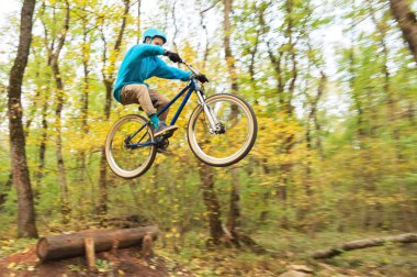 genç bir adam bir kask içinde sinekler bir kicker atladıktan sonra bir bisiklet üzerinde indi