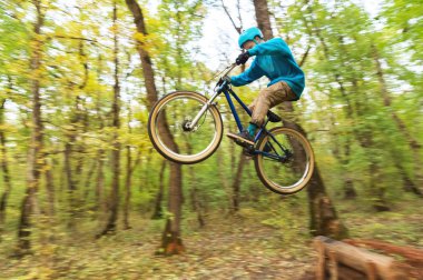 genç bir adam bir kask içinde sinekler bir kicker atladıktan sonra bir bisiklet üzerinde indi