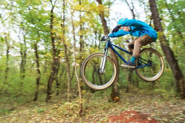 genç bir adam bir kask içinde sinekler bir kicker atladıktan sonra bir bisiklet üzerinde indi
