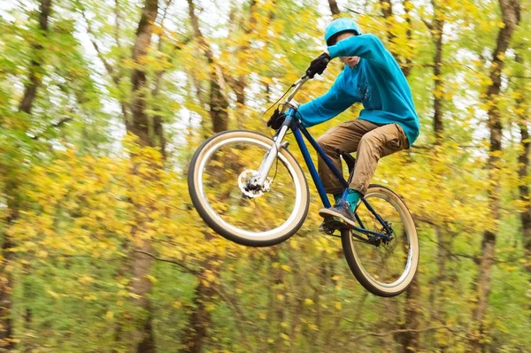 Un ragazzo con un casco vola atterrato su una bicicletta dopo essere saltato da un kicker — Foto Stock