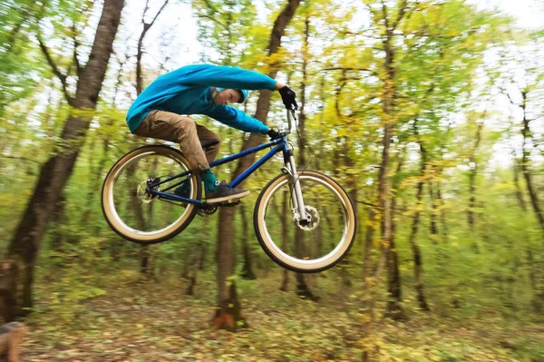 Un ragazzo con un casco vola atterrato su una bicicletta dopo essere saltato da un kicker — Foto Stock