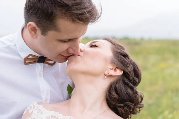 Ein paar Frischvermählte, die sich in der Natur in den Armen liegen — Stockfoto