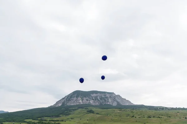 Tres globos azules volando al cielo — Foto de Stock