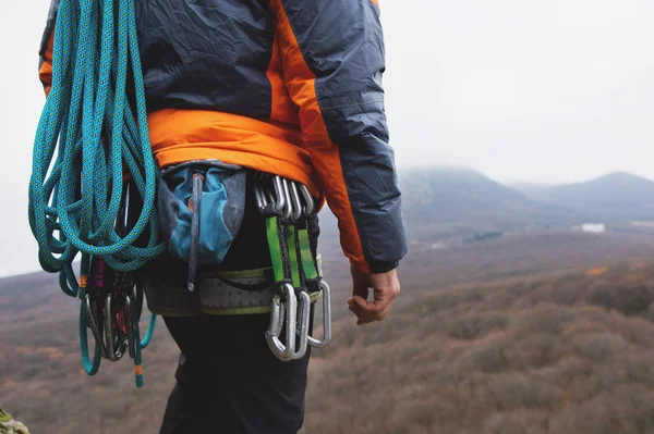 Close-up of a thigh climber with equipment on a belt, stands on a rock — Stock Photo, Image