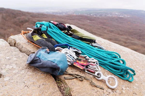 Альпинистское снаряжение - Мешок для магнезии лежит на скале рядом с канатом и карабины — стоковое фото