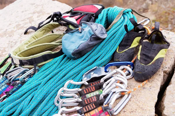 Equipo de escalada: la cuerda y las carabinas se ven desde el primer plano lateral. Una cuerda trepadora enrollada tendida en el suelo como fondo. Concepto de deporte al aire libre — Foto de Stock