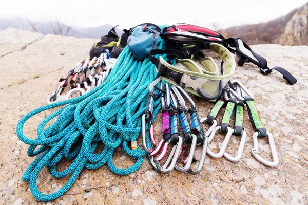 Equipamento de escalada - corda e carabinas vista a partir do close-up lateral. Uma corda de escalada enrolada deitada no chão como fundo. Conceito de esporte ao ar livre — Fotografia de Stock