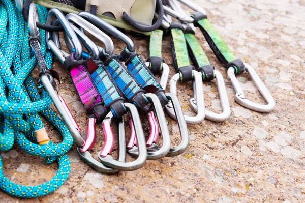 climbing equipment - a harness and a rope next to the carbines lie on a rock