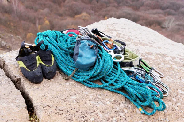 Climbing equipment - rope and carbines view from the side close-up. A coiled climbing rope lying on the ground as a background. Concept of outdoor sport