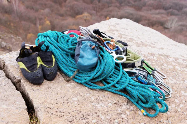 Kletterausrüstung - Seil und Karabinerblick von der Seite aus Nahaufnahme. Ein aufgerolltes Kletterseil, das als Hintergrund auf dem Boden liegt. Konzept des Outdoor-Sports — Stockfoto