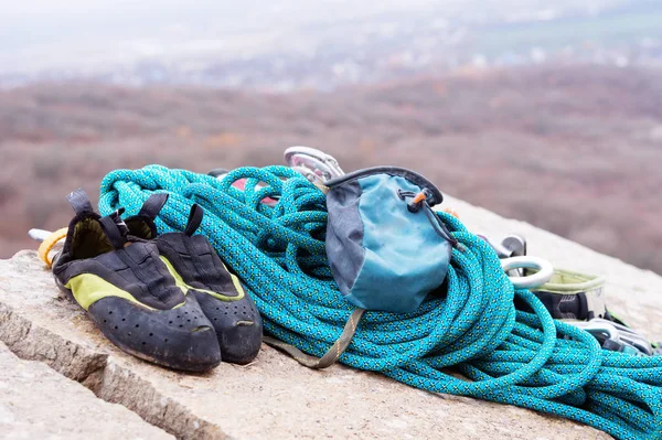 Equipo de escalada: la cuerda y las carabinas se ven desde el primer plano lateral. Una cuerda trepadora enrollada tendida en el suelo como fondo. Concepto de deporte al aire libre — Foto de Stock