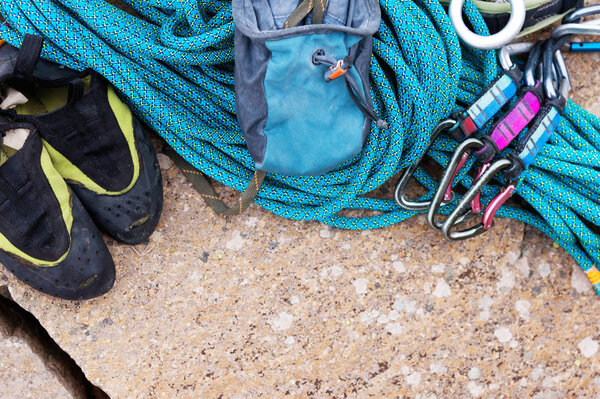 Climbing equipment - rope and carbines view from the top close-up. A coiled climbing rope lying on the ground as a background. Concept of outdoor sport