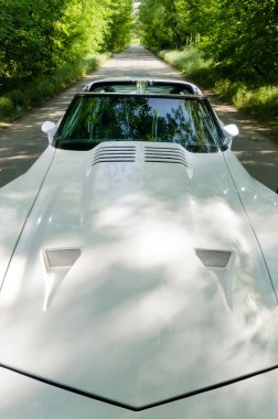 Nevinomyssc, Rusya Federasyonu - 13 Mayıs 2016: otomobiller. Eski Amerikan arabaları dışına fotoğraf. Chevrolet Corvette C3 1978s. Ön kaput ve bir ormandaki bir ülke yolda Üstten Görünüm