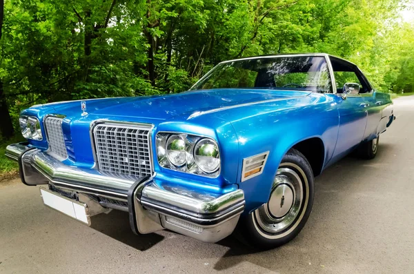 Nevinomyssc, russland - 13. Mai 2016: automobile. Offsite-Fotografien alter amerikanischer Autos. oldsmobile 98 1974s. Maschinentyp von vorne auf einer Landstraße im Wald — Stockfoto